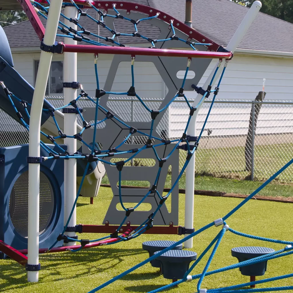 Modern playground climbing structure with blue rope net and artificial turf surface at Hoagland Park municipal playground.