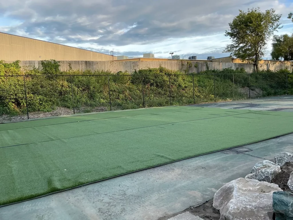 K9Grass artificial turf panels installed in fenced dog park with natural vegetation border, South Bend, Indiana