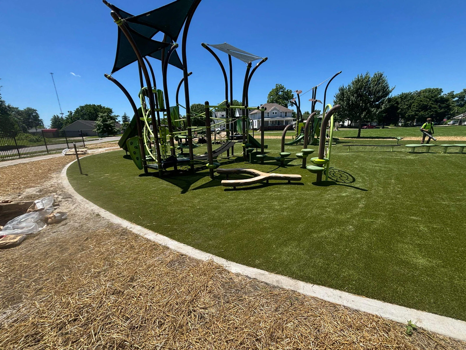 ForeverLawn Playground Grass Ultra installed around modern green playground equipment at Hanna Homestead Park, Indiana.