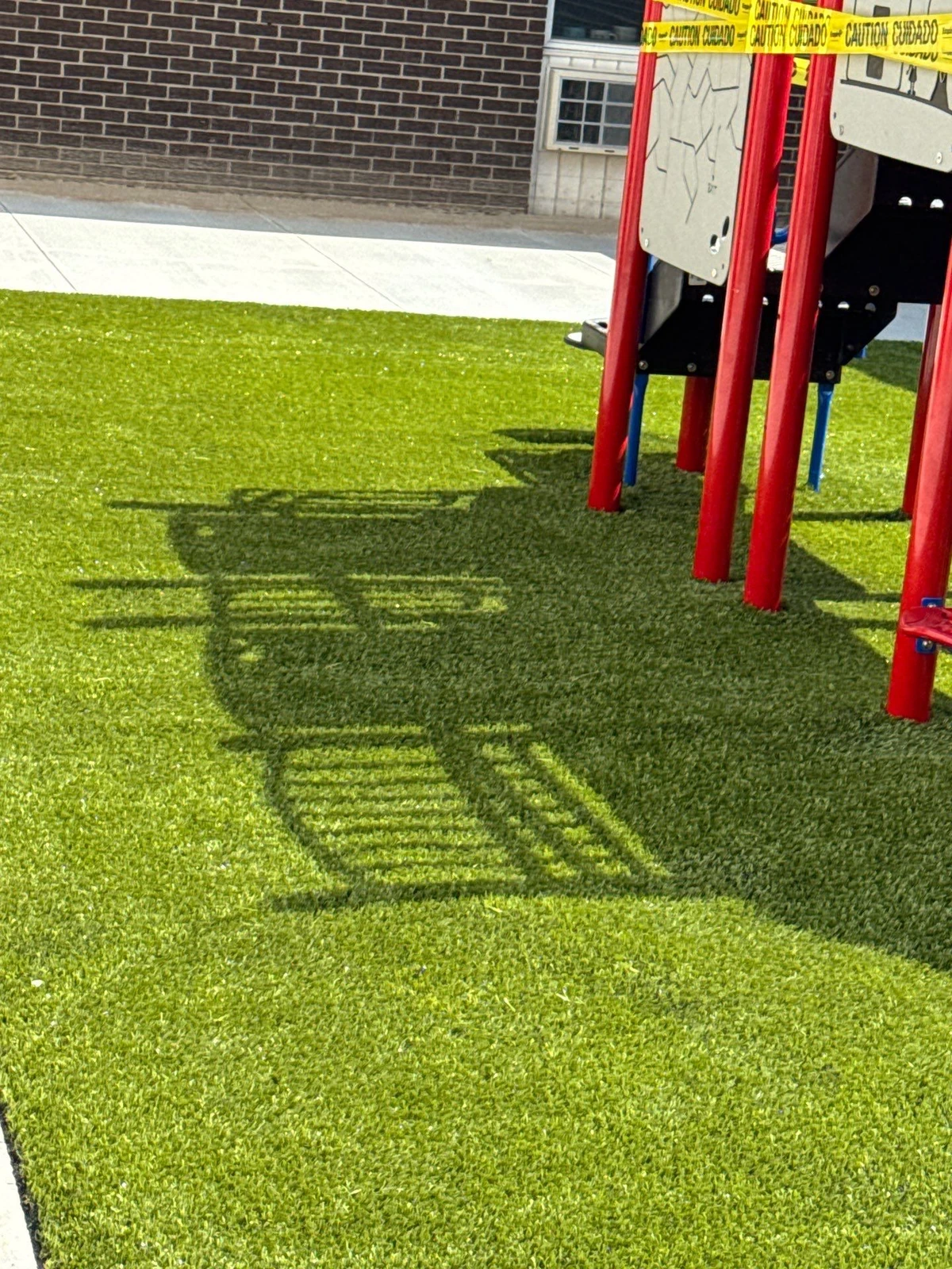 Red playground equipment on vibrant green ForeverLawn Playground Grass Ultra artificial turf at Lutheran Central School, Brownstown IN.