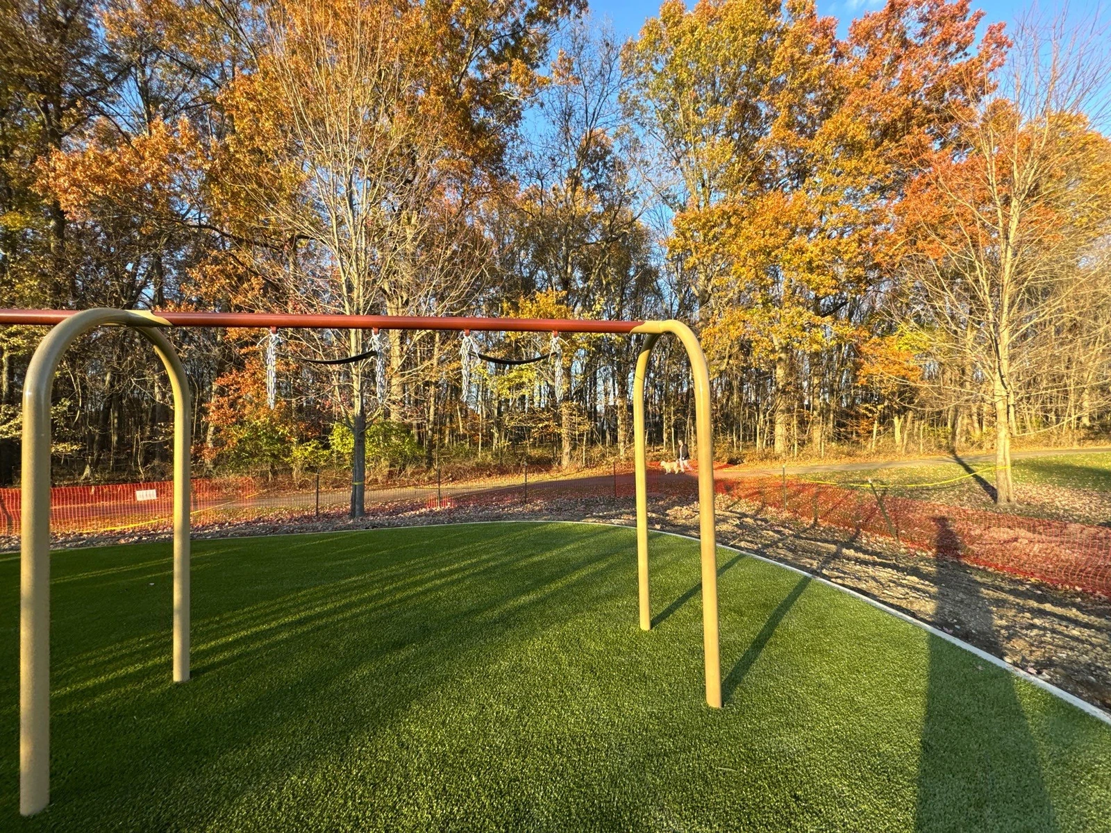 New Playground Grass Ultra artificial turf installed under swing set at McNamara Park, surrounded by autumn trees in Galena, OH.